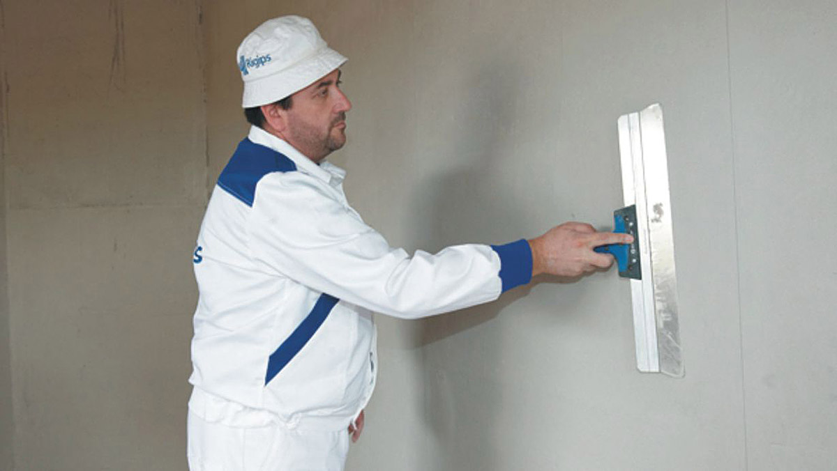 Aplikace sádrové omítky a stěrky v jednom materiálu pod názvem Rimano Glet XL. Finální srovnání povrchu bez broušení pomocí nerezové špachtle