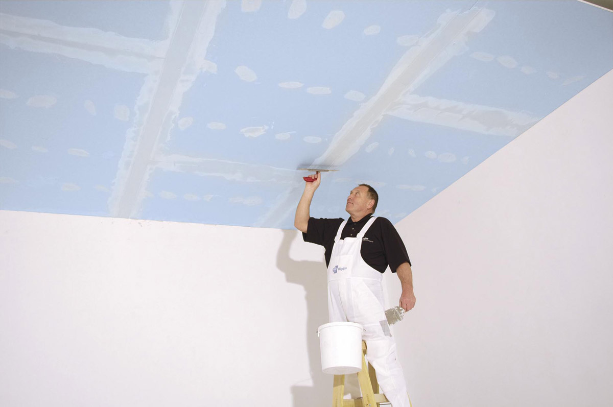 Tmelení modrého akustického sádrokartonového podhledu Rigips. Modré akustické systémy Rigips pomáhají zlepšit zvukovou izolaci v interiérech. Snížení stropu s modrými akustickými deskami Rigips je jen o 5 cm a přinese o výrazných 13 dB lepší zvukověizolační vlastnosti.